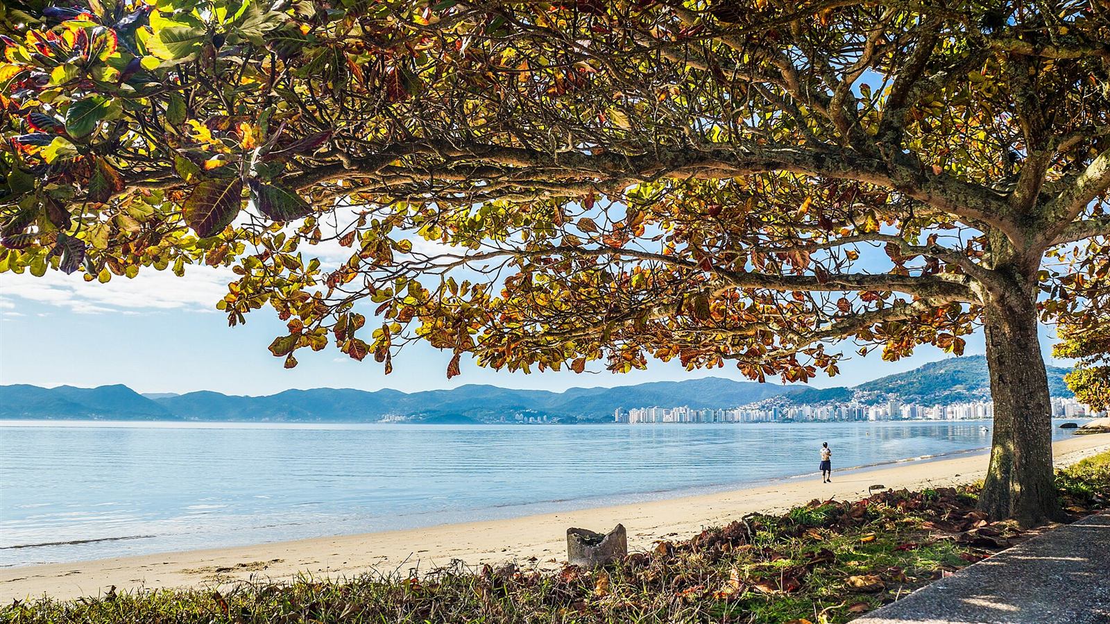 Praia do Balneário do Estreito, no continente, com a ilha de Florianópolis ao fundo